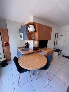 a small kitchen with a wooden table and chairs at Ti Gon - Le Cabanon Baulois in La Baule