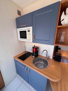 a small kitchen with a sink and a microwave at Ti Gon - Le Cabanon Baulois in La Baule