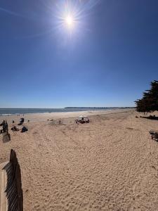 a sandy beach with the sun in the sky at Ti Gon - Le Cabanon Baulois in La Baule +4 photos