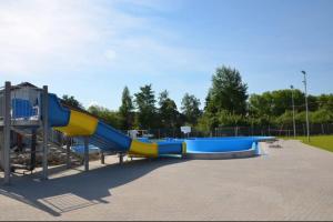 a blue and yellow slide at a playground at Apartament Międzylesie in Międzylesie
