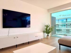 a living room with a large tv on a wall at Nooba Barreiro Apartment in Barreiro