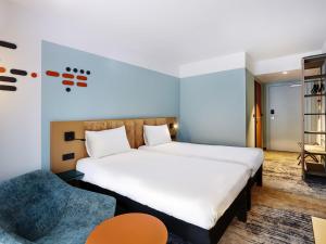 a hotel room with a bed and a chair at ibis Styles Kraków Centrum in Krakow +82 photos