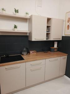 a kitchen with white cabinets and a wooden counter top at Apartament Międzylesie in Międzylesie