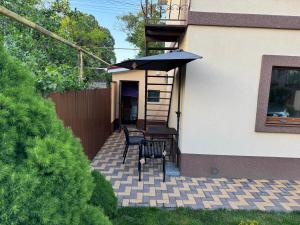 a patio with a table and an umbrella at Тихий дворик in Odesa