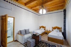a room with two beds and a couch and a table at Khalid Boutique in Bukhara +96 photos