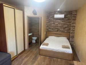 a bedroom with a bed and a brick wall at Тихий дворик in Odesa