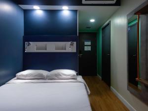 a bed in a room with a blue wall at ibis budget Maceió Pajuçara in Maceió