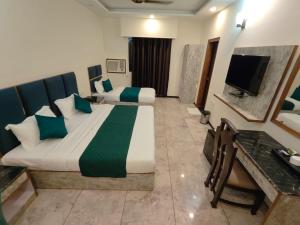 a hotel room with two beds and a television at Hotel Maurya Heritage In Karol Bagh in New Delhi