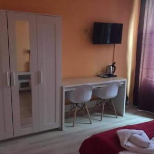 a bedroom with a desk and two chairs and a bed at Y Panzió in Balatonlelle