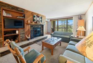 a living room with a couch and a fireplace at Evergreen Condominiums by Vail Resorts in Keystone