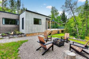 a backyard with chairs and a house in the woods at La Trêve Mont Tremblant in La Conception