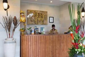 eine Frau, die an einer Theke in einem Geschäft sitzt in der Unterkunft Sandi Agung Villa in Seminyak + 37 Fotos