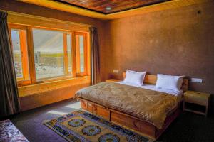 a bedroom with a bed with a large window at Eco Residence Pangong in Lukung