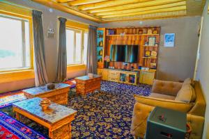 a living room with a couch and a tv at Eco Residence Pangong in Lukung