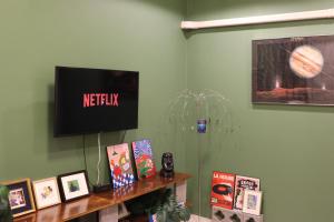 a room with a television and a shelf with books at Krabi Buddy House in Ban Khlong Chi Lat