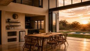a dining room with a wooden table and chairs at Sanyati Villa in Mmukubyane