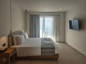 a bedroom with a large bed and a television at Aeolia Seaside Hotel in Kardamaina