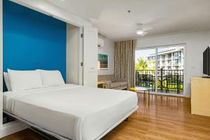 a bedroom with a white bed and a blue wall at WorldMark Kihei in Kihei