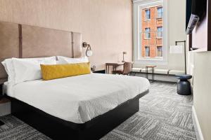 a bedroom with a large bed with a yellow pillow at The Wills Hotel in Cumberland