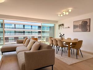 a living room with a couch and a table with chairs at Nooba Barreiro Apartment in Barreiro