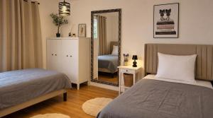 a bedroom with two beds and a mirror at Dreiländer Blick Apartment Premium in Lörrach