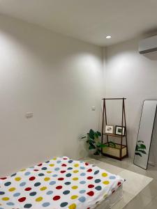 a bed with a polka dot blanket in a room at Krabi Buddy House in Ban Khlong Chi Lat