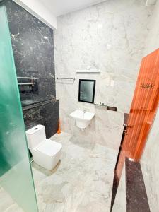 a bathroom with a toilet and a sink at JayKay Resort in Pūrnānkuppam +17 photos