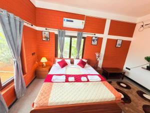 a bedroom with a large bed with red walls at JayKay Resort in Pūrnānkuppam