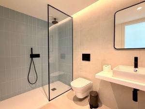 a bathroom with a shower and a toilet and a sink at Nooba Barreiro Apartment in Barreiro +38 photos