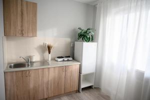 a kitchen with a sink and a white refrigerator at Side Apartments in Rakvere