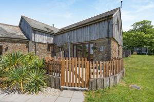 an old stone house with a wooden fence at 3 Bed in Bideford oc-05171 in Woolfardisworthy