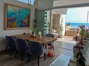 a dining room with a wooden table and blue chairs at Spacious 4BR Duplex with Pool in Punta Hermosa in Punta Hermosa