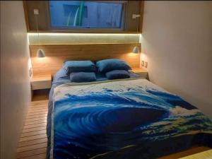 a bedroom with a bed with a painting of a wave at Spacious 4BR Duplex with Pool in Punta Hermosa in Punta Hermosa