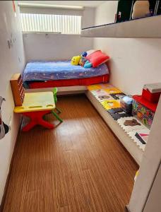 a small bedroom with a bunk bed and a chair at Spacious 4BR Duplex with Pool in Punta Hermosa in Punta Hermosa