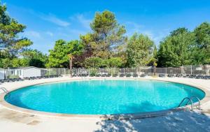 a swimming pool with chairs and a fence at camping des iscles 167 in La Roque-dʼAnthéron