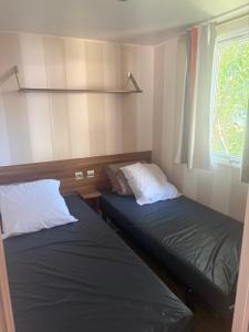 two beds in a small room with a window at camping des iscles 167 in La Roque-dʼAnthéron +4 photos