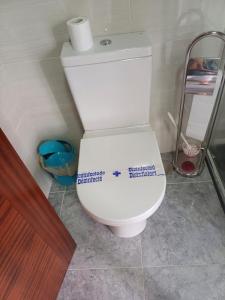 a bathroom with a toilet with a sticker on it at O Cobo Vacacional in Padrón +46 photos
