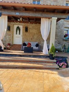 a patio with a white door and curtains at O Cobo Vacacional in Padrón