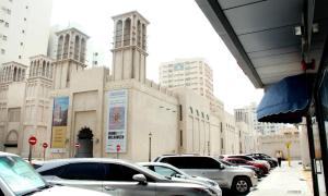 a row of cars parked in front of a building at BARAKAH HOTEl in Sharjah