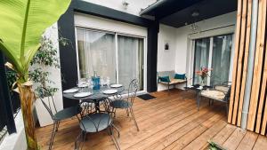 a balcony with a table and chairs on a deck at Sabrina in Tarbes +1 photo