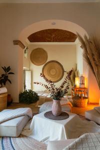 a room with a table with a vase of flowers on it at Habibi Hotel and SPA in San Miguel de Allende