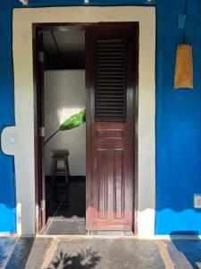 a blue building with a wooden door and a stool at Casa Acquamarina in Atins