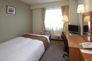 Postel nebo postele na pokoji v ubytování Toyooka Sky Hotel