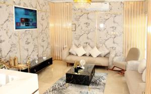 a living room with a couch and a tv at BARAKAH HOTEl in Sharjah
