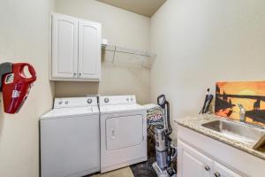 a kitchen with a white washer and a sink at Sunset View Deck! Lake Eufaula Family Getaway in Stigler +22 photos