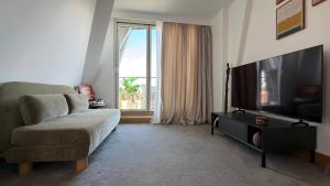 a living room with a couch and a flat screen tv at The Apex Penthouse, Hyde Park in London
