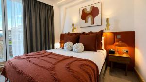 a bedroom with a large bed with a large window at The Apex Penthouse, Hyde Park in London