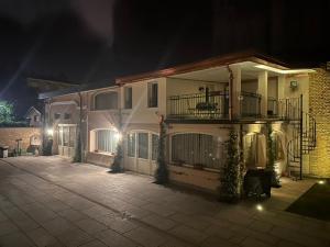 a large apartment building with a balcony at night at Villa Simona in Voghera