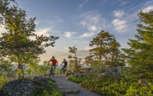 two people riding bikes on a trail at Pitkälampi Private Lake Lodge in Jokikylä +5 photos
