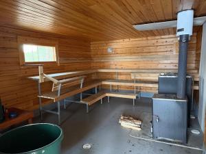 a room with wooden walls and benches in a cabin at Pitkälampi Private Lake Lodge in Jokikylä